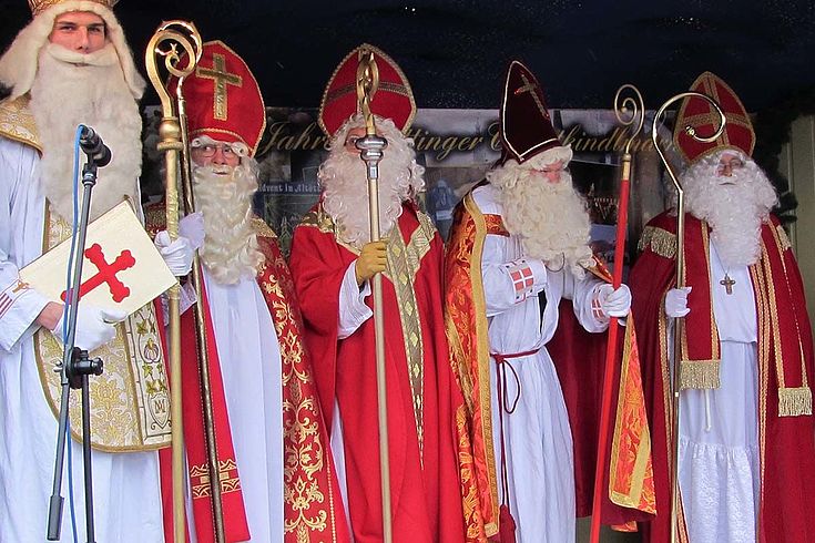 Fünf Nikolause in voller Festmontour mit Stäben, Mänteln und Bärten