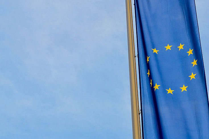 EU-Flagge an einem Fahnenmast, darüber der Himmel