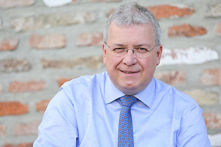 Markus Ferber, MdEP, älterer Herr im Hemd mit Krawatte lächelt anpackend. 