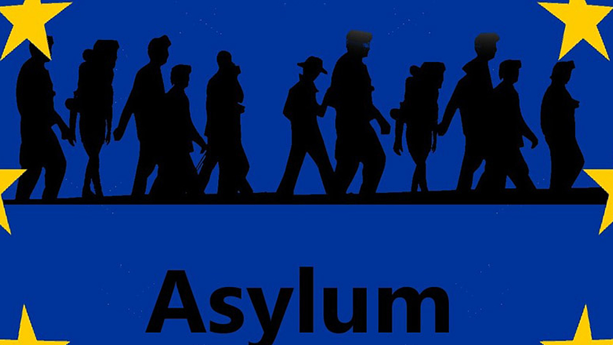 Die Flagge der Europäischen Union, innerhalb der europäischen Stern sind wandernde Menschen als schwarze Schatten dargestellt, darunter steht Asylum.