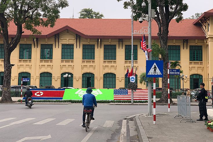 Ein Fahrradfahrer in Vietnams Hauptstadt Hanoi vor den Gipfel-Plakaten