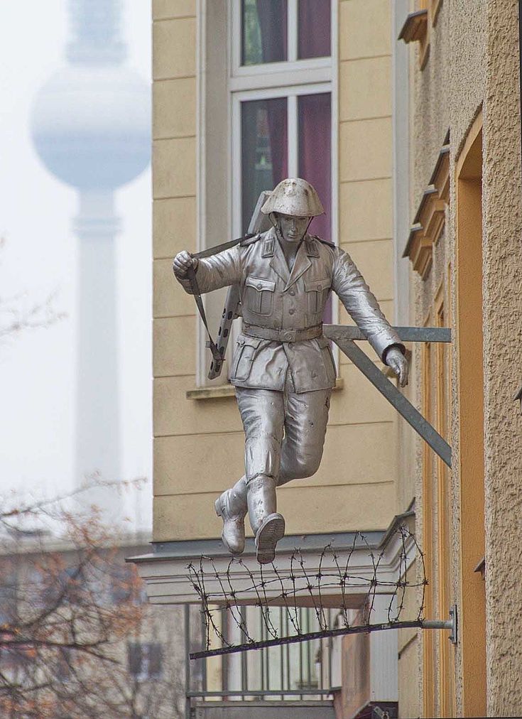 Denkmal des berühmten Soldaten, der gerade noch über die Berliner Mauer springt, die sich gerade im Bau befindet.