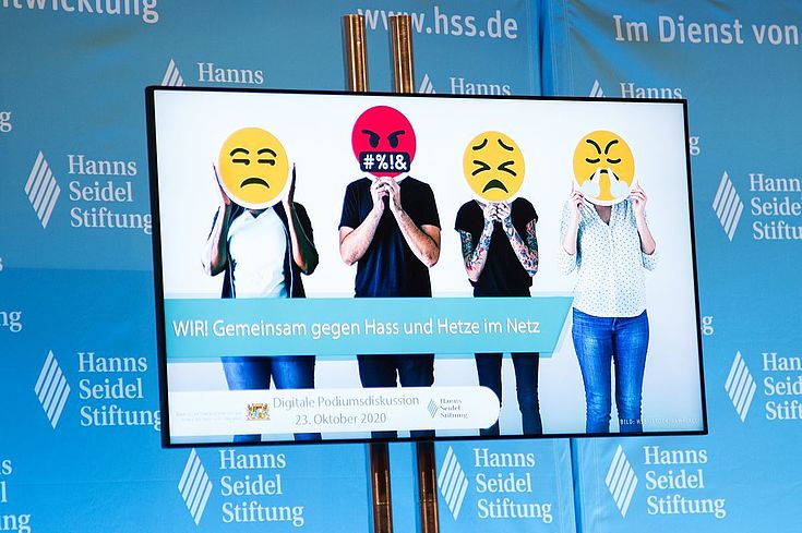 Bildschirm mit vier Menschen mit Smileys vor dem Gesicht
