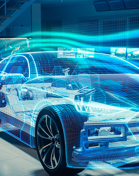 Ingenieur mit Virtual Reality Brille steht neben einem Auto, das als 3D-Model dargestellt ist
