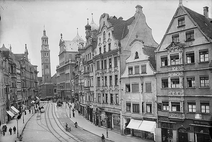 Eine alte Aufnahme der Maximiliansstraße mit den Trambahnschienen in der Mitte und Passanten