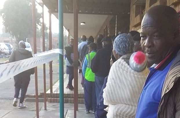 eine Menschenschlange vor einem Wahllokal