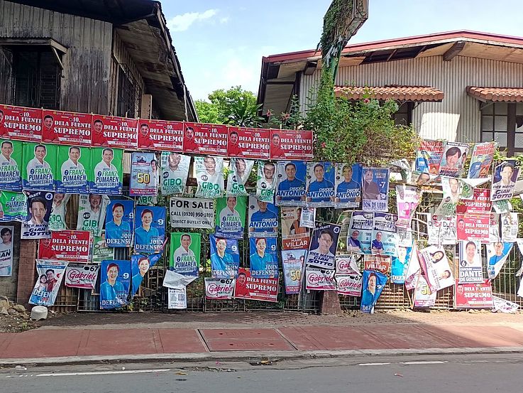Eine Fülle von Wahlplakaten hängen an einem Straßenzaun.
