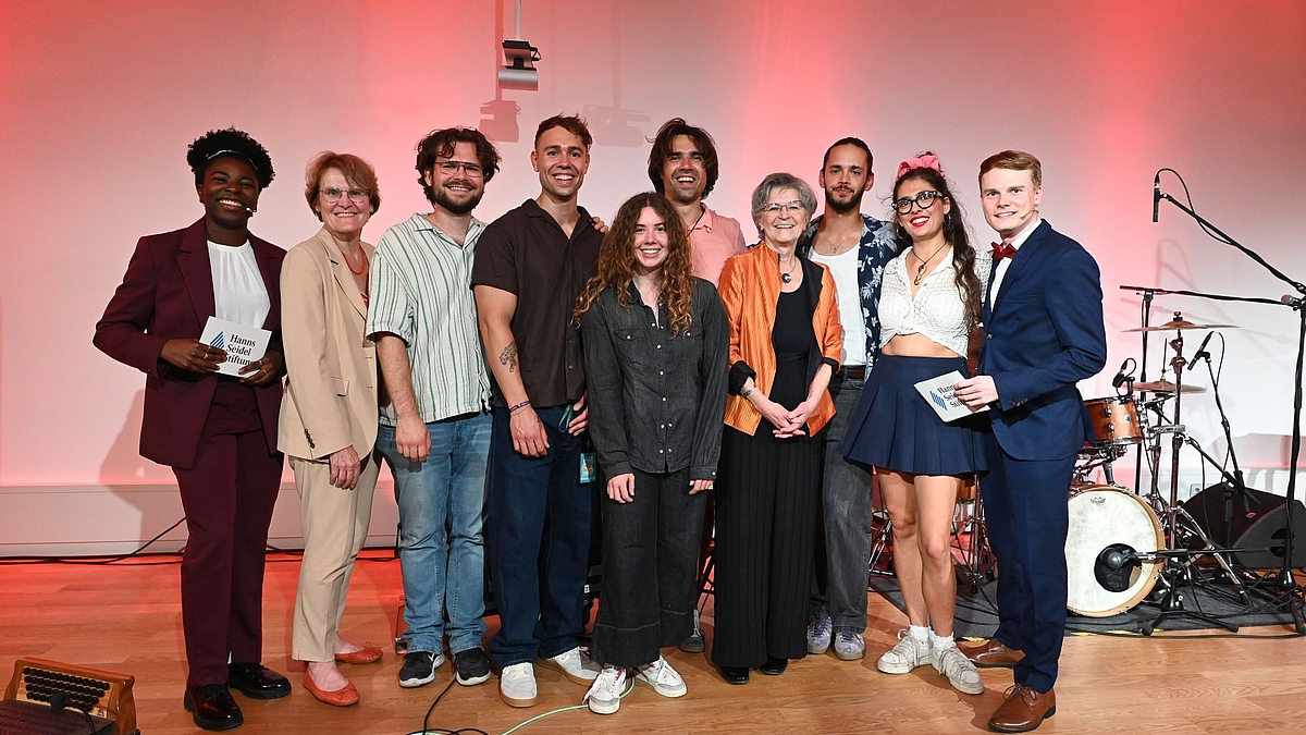 v.li.: Moderatorin und Stipendiatin Joela Aithnard, Juryleiterin Dr. Jutta Möhringer, Samuel Feimer (Holza), Max Leitgeb (Holza), Larissa Felber (Stipendiatin undSocial Media-Team), Luca Bo Hansen (Lina Bó), die stellv. Vorsitzende Susanne Breit-Keßler, Sebastian Holzer (Holza), Celina von Wrochem (Lina Bó), Moderator und HSS-Stipendiat Lukas Hässner