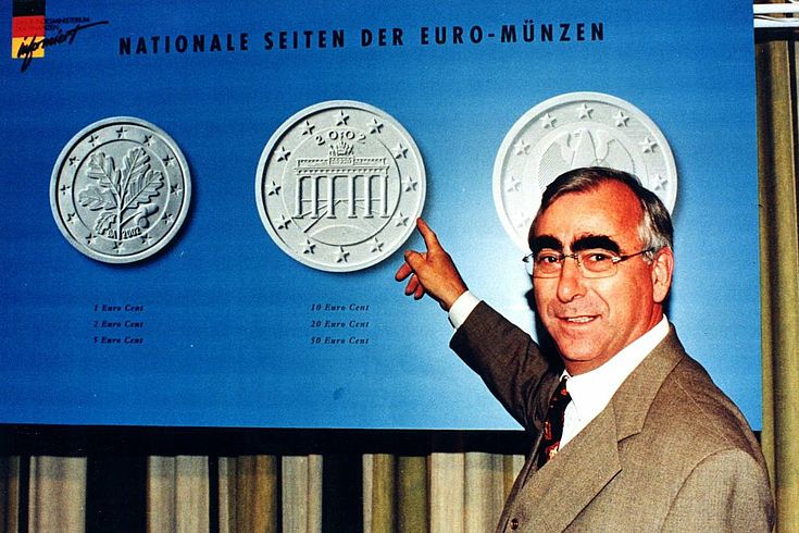 Waigel deutet auf ein Bild der neuen Euromünzen