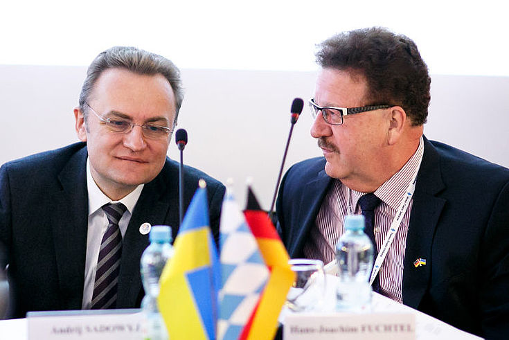 Andreij Sadowij und Hans-Joachim Fuchtel sitzen an einem Konferenztischchen und diskutieren miteinander.