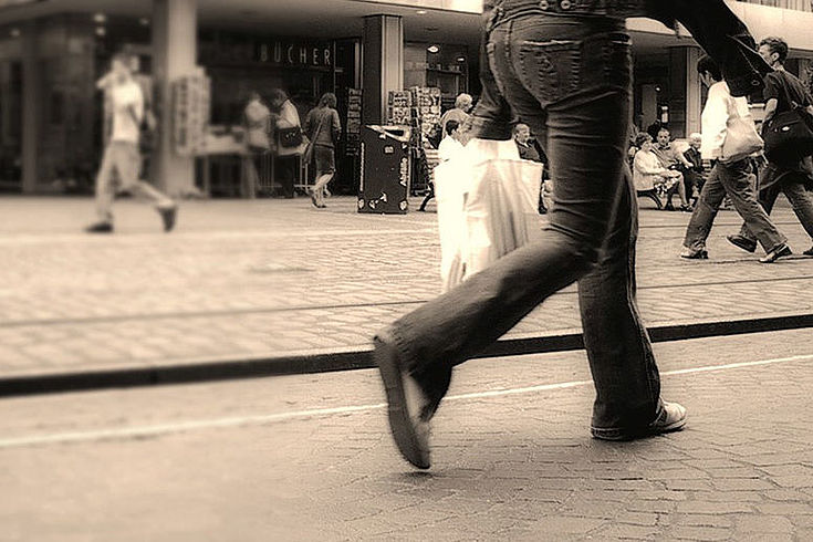 Ein Mensch mit Plastiktüte beim Einkaufen in einer Fußgängerzone