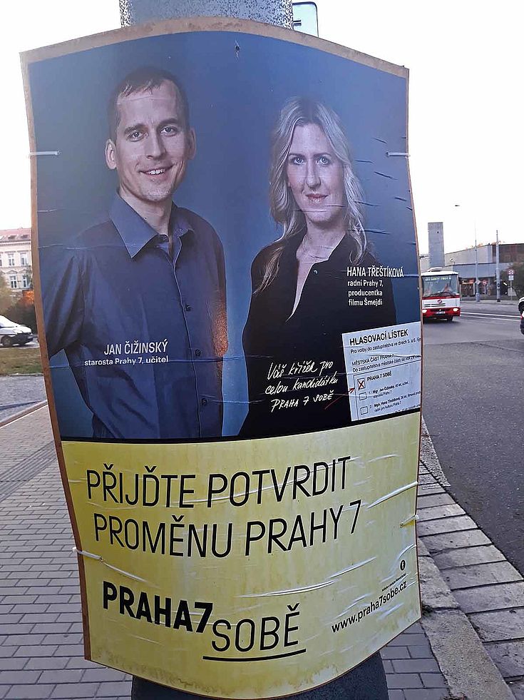 Wahlplakat mit einem lächelnden Mann und einer lächelnden Frau.