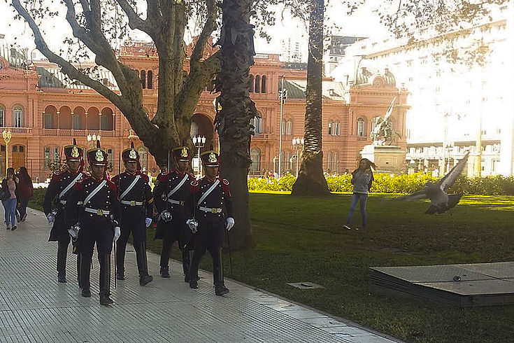 Das rosafarbige Regierungsgebäude von Argentinien im Hintergrund mit uniformierter Garde auf einer Straße 