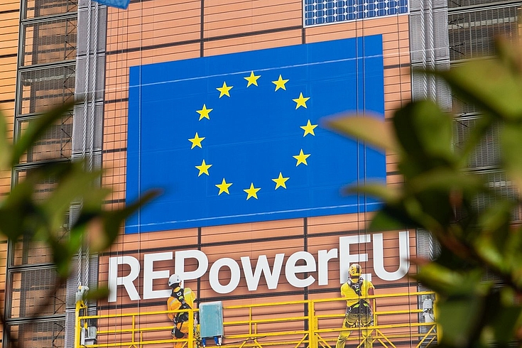 Eine Häuserwand ist mit der Fahne der EU versehen und der Aufschrift REPowerEU.