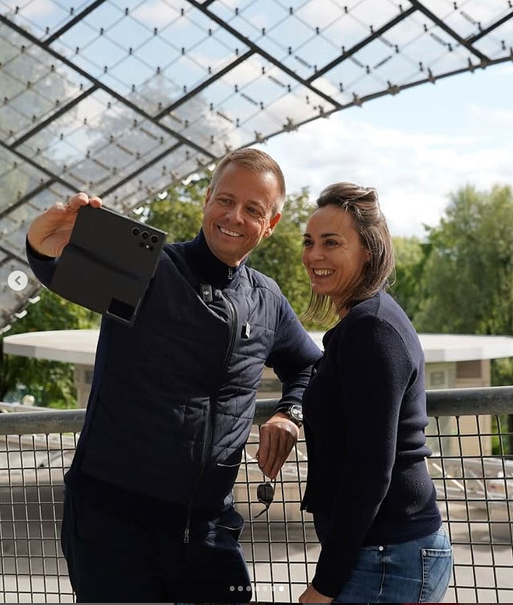 Die Münchner Stadträtin Veronika Mirlach steht im Olympiastadium und macht ein Selfi mit einem Kollegen.