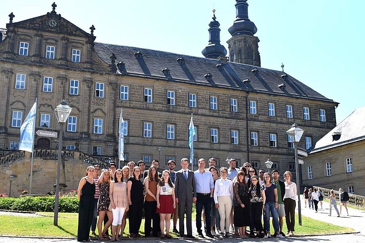 In der Mitte: Staatssekretär Thomas Silberhorn (l.) und der Leiter des HSS-Hauptstadtbüros, Dr. Alexander Wolf (r.) mit den Parlamentsstipendiaten vor Kloster Banz