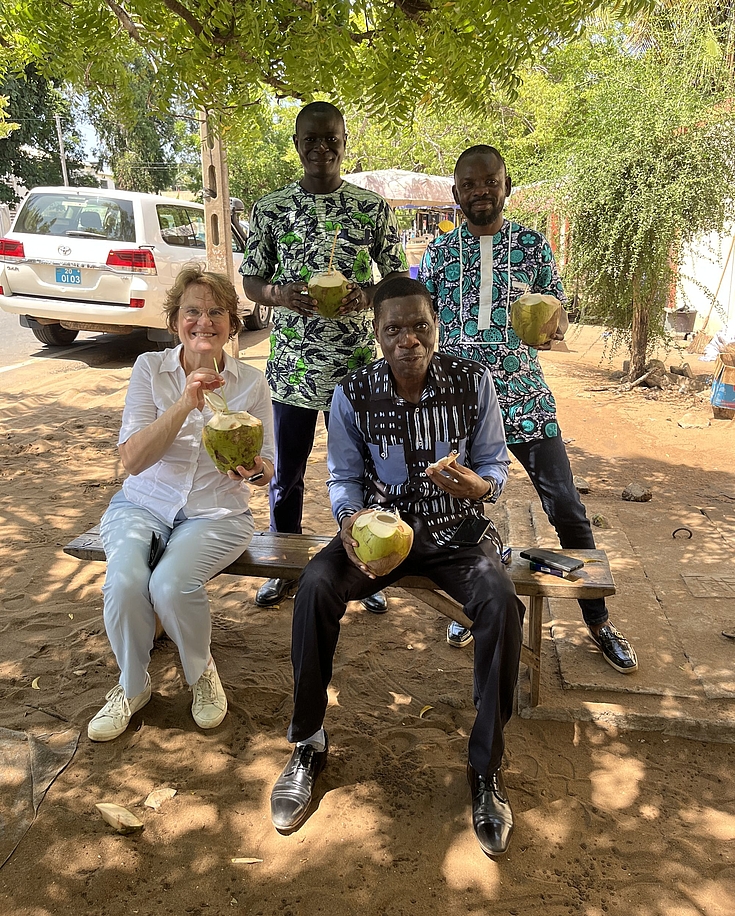 Dr. Jutta Möhringer, Leiterin des Instituts für Begabtenförderung (links), beim Kokosnusstrinken mit Altstipendiat Dr. Benjamin Afanvi.