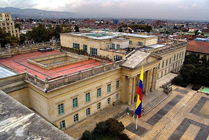 Blick auf den Präsidentenpalast von einer umgebenden Mauer aus, ein eindrucksvolles Sandsteingebäude mit Säulen im klassischen Stil.