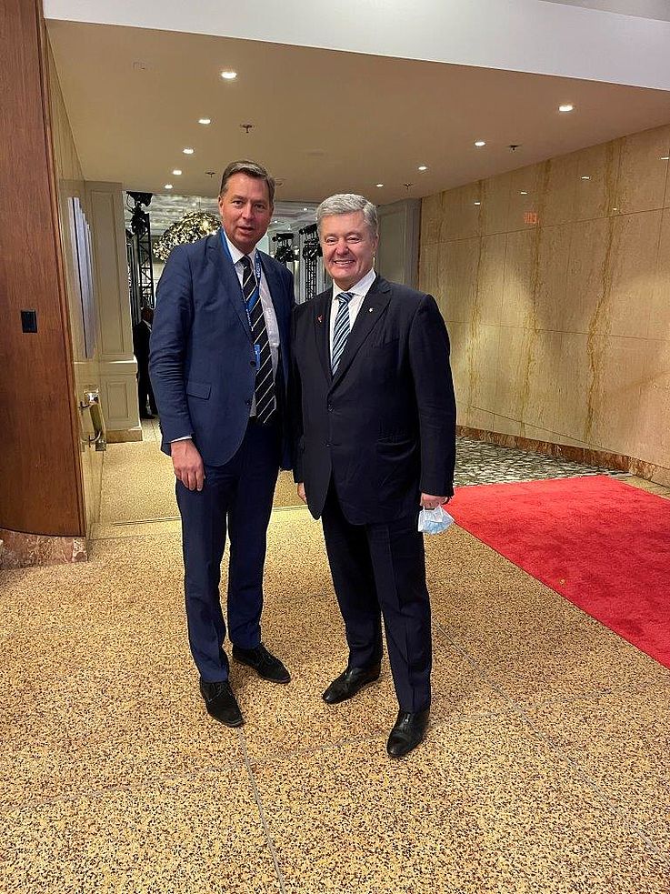 Mayer und Poroschenko in einem Tagungssaal nebeneinander. Lachen. 