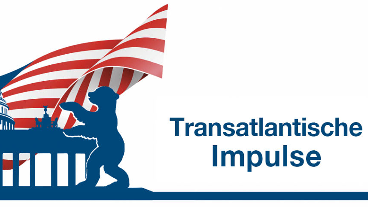 Logo: mit dem US-Capitol, dem Brandenburger Tor und dem Berliner Bären. Im Hintergrund die US-Flagge