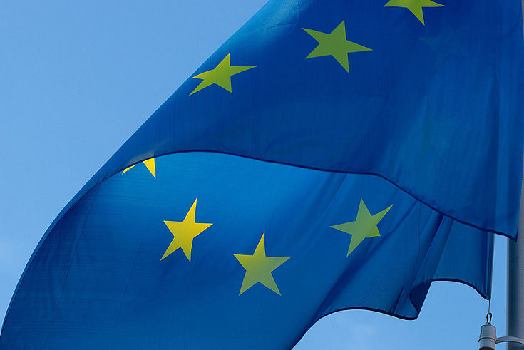 Europaflagge weht vor wolkenfreiem Himmel