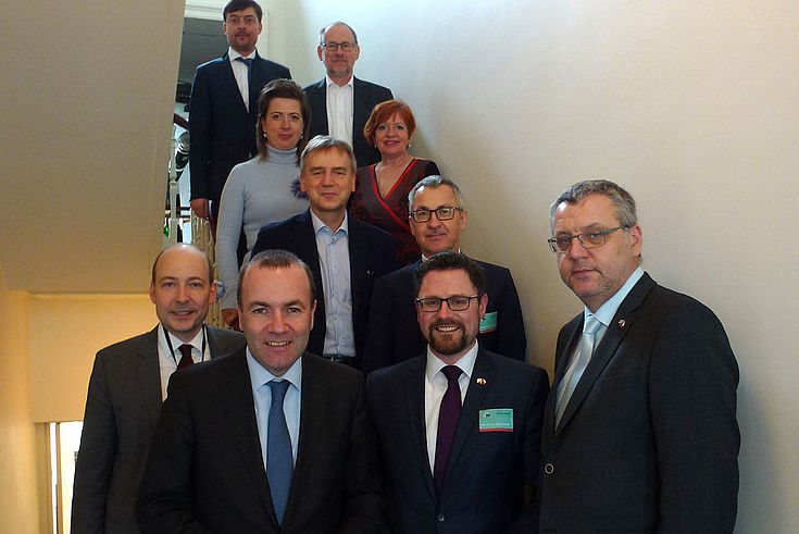 Gruppe auf einer Treppe in einem äußerst langweiligen Treppenhaus von unten aufgenommen. Manfred Weber ganz vorne.