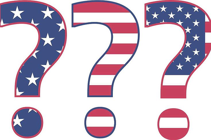 Drei Fragezeichen mit USA Flagge darauf