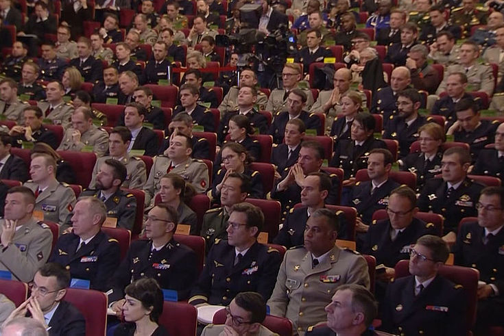 Viele Männer in Uniform in einem Saal. Zuhörend.