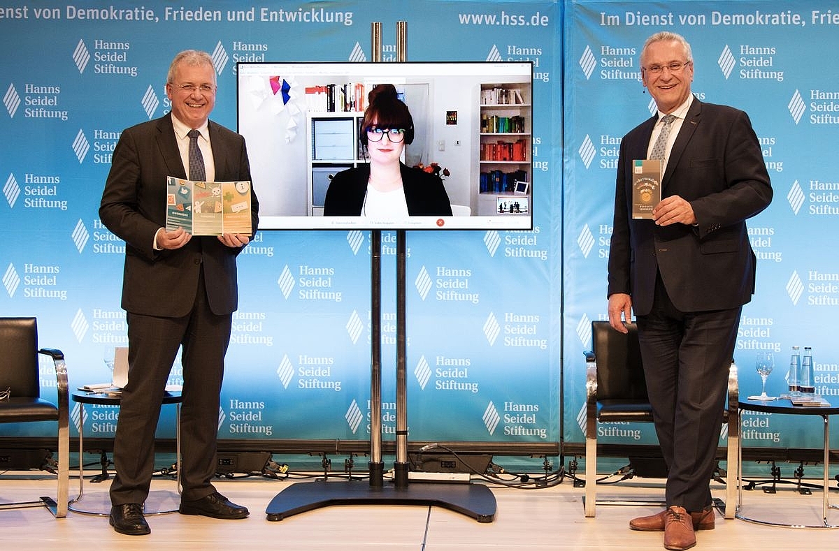 Markus Ferber und Joachim Herrmann halten die Hatespeech Broschüre in den Händen