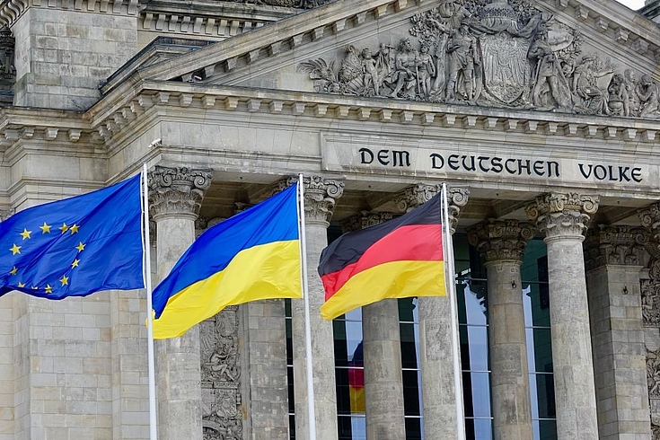 Vor dem Bundestag wehen die Fahnen der EU, Deutschlands und der Ukraine.
