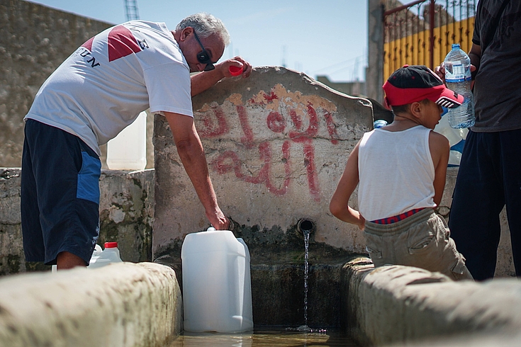Menschen holen an einer natürlichen Quelle in Nordtunesien Wasser in Kanistern und Flaschen. Wasser gilt während den Hitzewellen als Luxusgut.